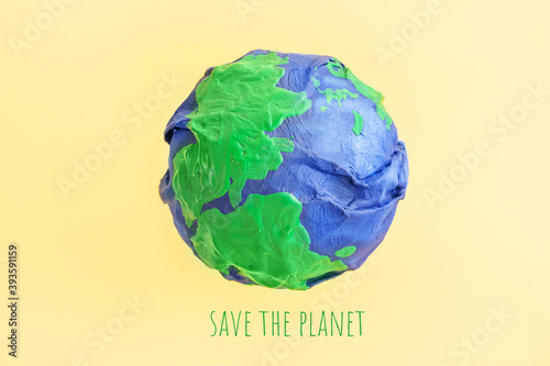Fototapeta Naklejka Na Ścianę i Meble -  Ecology concept, environment, plastic free, saving the planet. Model of planet wrapped in a plastic bag. The seas and continents are painted with paint. Shriveled planet Earth. Minimalism, copy space.