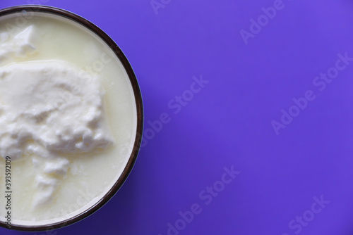 close up of fresh yogurt in a bowl on color background 