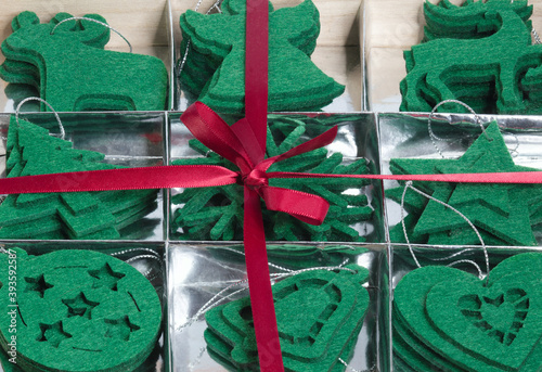 Obraz na płótnie Christmas frame with a gift box full of green felt toys they lie on a silver substrate - this is.a Christmas tree, a ball, a star, an elk , a deer, a bell, a heart w salonie