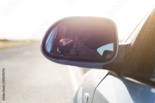 Muslim driver in the reflection of the rearview mirror