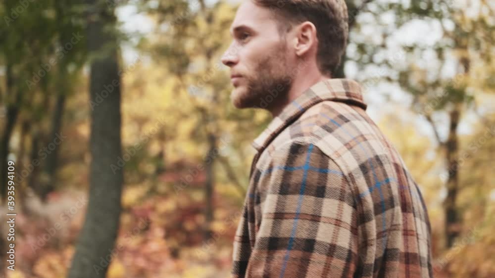 A side view of a handsome man is walking in the park A side view of a handsome man is walking in the park