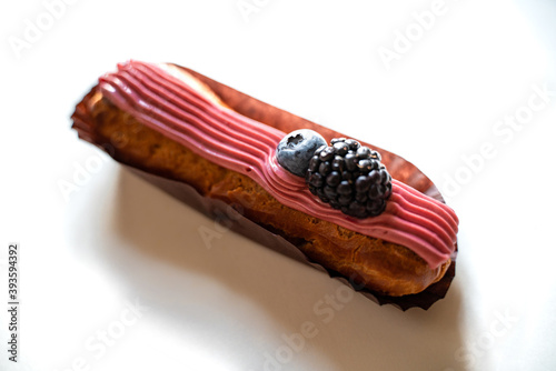 Fotografia Crispy eclair with pink cream and blackberries and blueberries