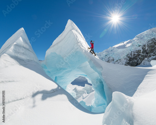 Man in red Ice climbing on The Tasman Glacier (Haupapa) which is the largest glacier in the Southern Alps, South Island, New Zealand.  photo