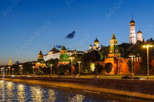 View of the Kremlin embankment, the towers of the Kremlin, the Grand Kremlin Palace, Ivan the Great Bell Tower in the late evening in August. Moscow, Russia