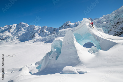 Man in red Ice climbing on The Tasman Glacier (Haupapa) which is the largest glacier in the Southern Alps, South Island, New Zealand.  photo