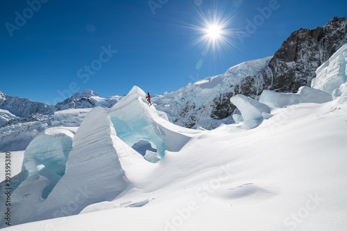 Man in red Ice climbing on The Tasman Glacier (Haupapa) which is the largest glacier in the Southern Alps, South Island, New Zealand.  photo