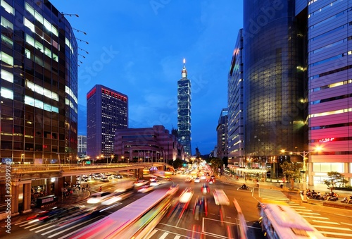 Panoramic view of a street corner in Taipei City with busy traffic trails at rush hour ~ Beautiful night scenery of Taipei 101 Tower and World Trade Center in XinYi Commercial Area in Taipei downtown