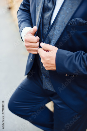 Groom is holding hands on the jacket , wedding suit