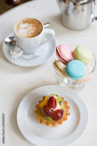 Coffee and macarons desserts on a cafe table
