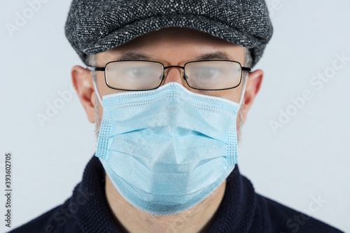 Man wearing a surgical mask and fogged up glasses. Protective measure during coronavirus pandemic