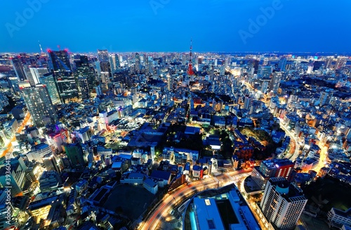 Aerial panorama of Tokyo Downtown at blue dusk with a view of illuminated Tokyo Tower among crowded buildings   the light trails of busy traffic on streets   highways Romantic nightscape of Tokyo City