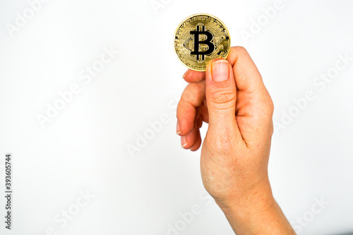 Bitcoin: The new virtual money / Close Up shot of Hand holdling one golden Bitcoin: Business, Money and Technology Concept 