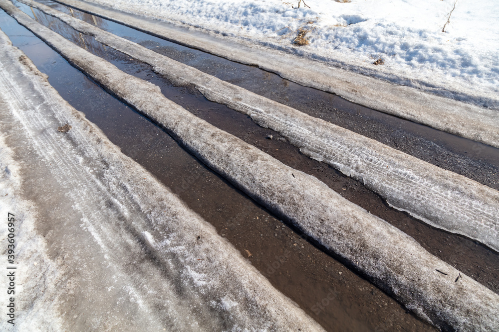 The road with melting snow in nature.