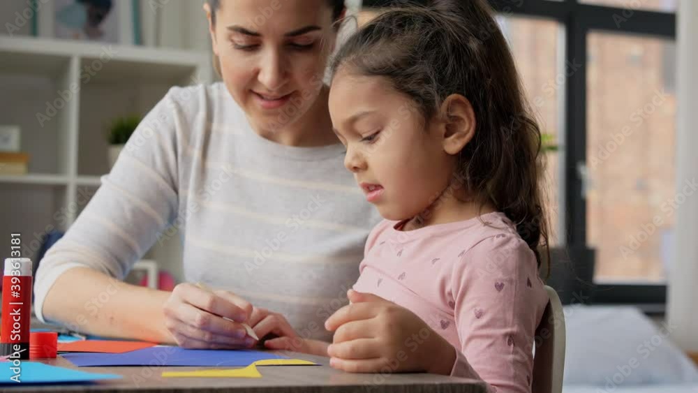 family, art and craft concept - mother spending time with her little daughter making applique of color paper and drawing at home family, art and craft concept - mother spending time with her little daughter making applique of color paper and drawing at home