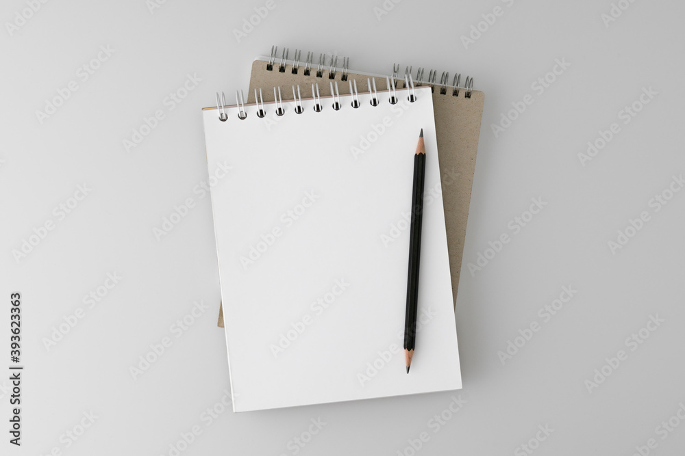 Open, office Notepad for notes on a spiral spring with a pencil on a gray background. School notebooks. Clean empty space, layout. Stylized stock photos. The view from the top. Mock-up. Open, office Notepad for notes on a spiral spring with a pencil on a gray background. School notebooks. Clean empty space, layout. Stylized stock photos. The view from the top. Mock-up.