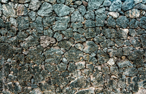 Wall of volcanic stones with grunge texture. Rock background lava abstract wallpaper.