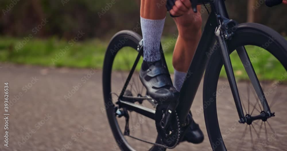Wheels of black professional bicycle going uphill on asphalt road Wheels of black professional bicycle going uphill on asphalt road