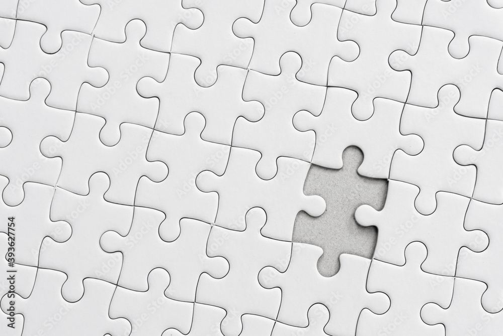 White jigsaw puzzle pattern background. placing last piece of jigsaw puzzle.