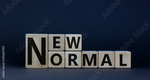 Concept words 'new normal' on cubes on a beautiful dark wooden background. Business and covid-19 pandemic concept. Copy space.
