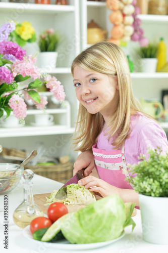 Portrait of cute little girl preparing fresh salad