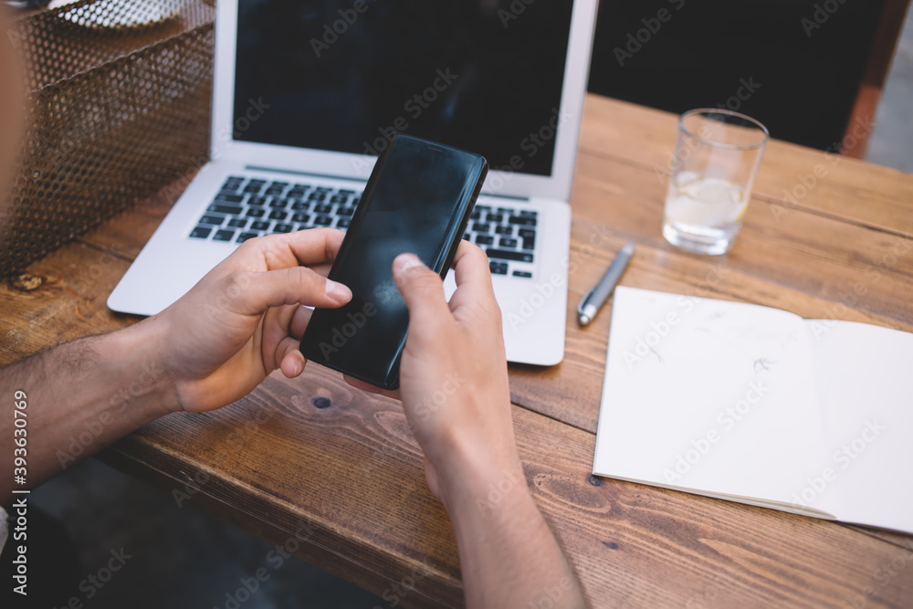 Unrecognizable man browsing smartphone in cafe Unrecognizable man browsing smartphone in cafe