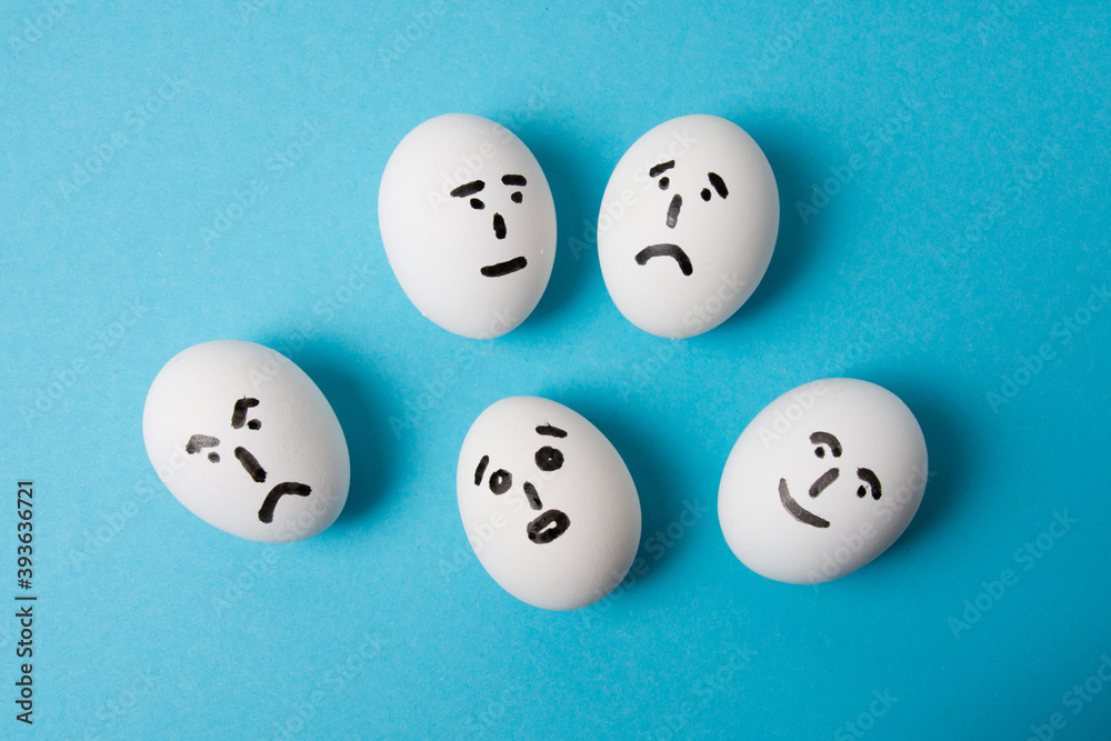 Eggs with faces and different emotions: surprise, indifference, sadness, anger and joy. Isolate on a blue background. Eggs with faces and different emotions: surprise, indifference, sadness, anger and joy. Isolate on a blue background.