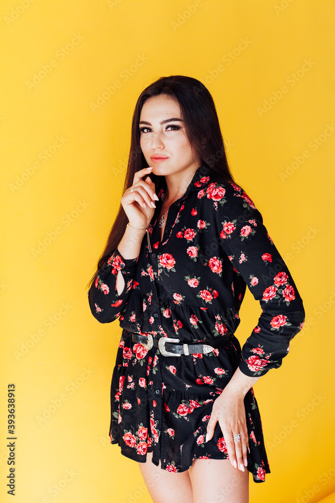 Beautiful brunette woman in black dress with flowers posing Beautiful brunette woman in black dress with flowers posing
