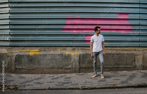 Young bearded hipster guy wearing white blank t-shirt. Mock-up for print. T-shirt template.