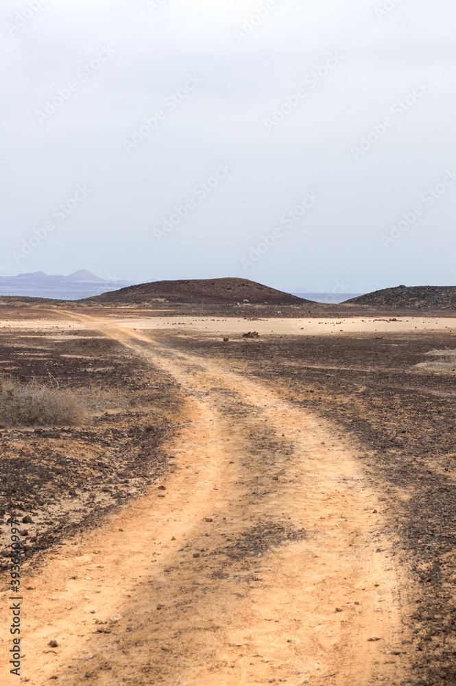 Desert path in arid and mountainous landscape of Fuerteventura, Spain. Desert path in arid and mountainous landscape of Fuerteventura, Spain.