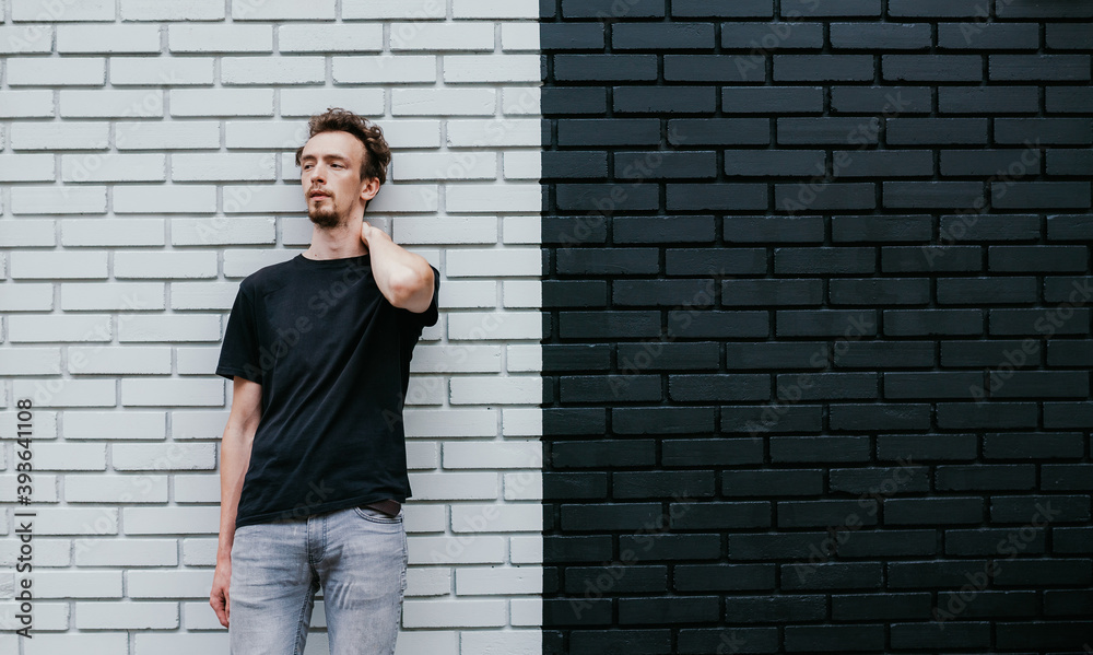 Young charismatic hipster guy wearing black blank t-shirt. Mock-up for print. T-shirt template.
