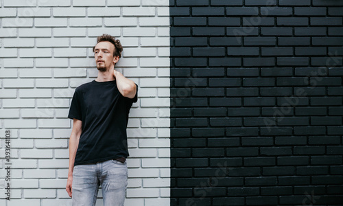 Young charismatic hipster guy wearing black blank t-shirt. Mock-up for print. T-shirt template.