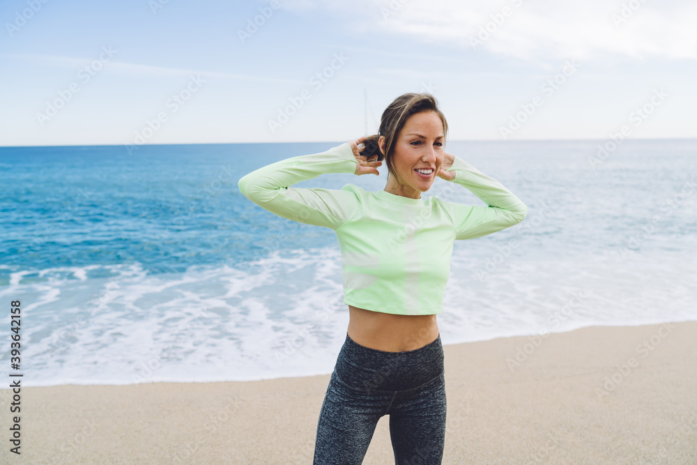 Shapely middle aged woman having workout on ocean coast Shapely middle aged woman having workout on ocean coast