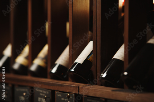 Tableau sur toile Wine cellar with elite drinks on shelves with written names