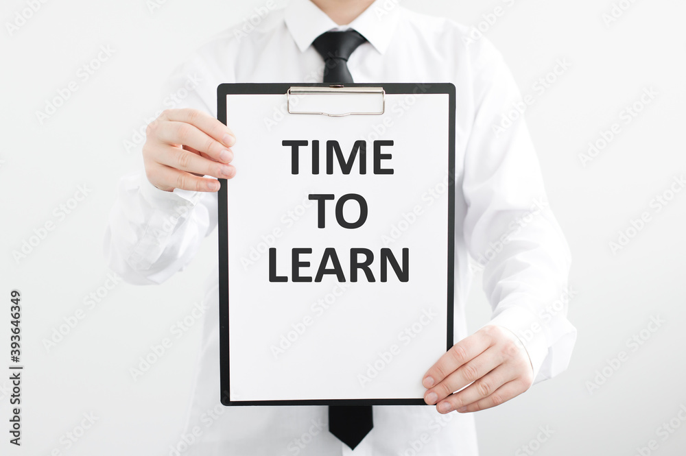 businessman holding a card with text TIME TO LEARN on light isolated background. businessman holding a card with text TIME TO LEARN on light isolated background.