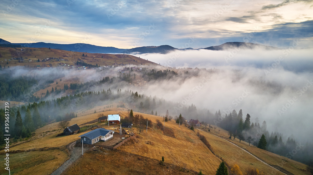 November morning. Morning fog in mountain valley. Forest covered by low clouds. Misty fall woodland