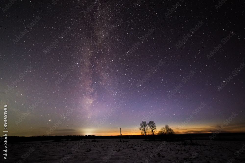 the beautiful glow of the sunset adjoins the milky way in the starry sky
