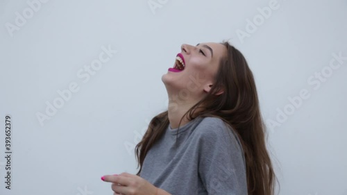 Nice girl in a gray T-shirt in a state of happiness. Portrait of charming cute long straight hair and gesticulating emotionally, laughing. Positive emotions, feelings and reaction. FullHD footage photo