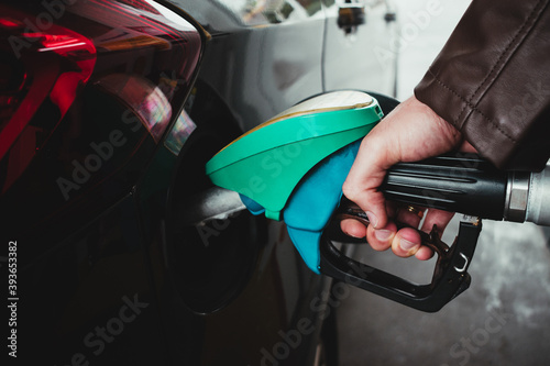 detail of a man's hand pouring gasoline into a car © Margalliver