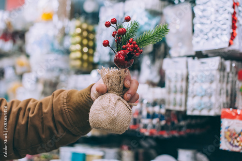 A man in a supermarket holds decorative holiday decorations in his hands.