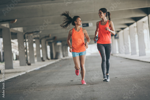 Two female runners jogging around the city .Urban workout concept. 