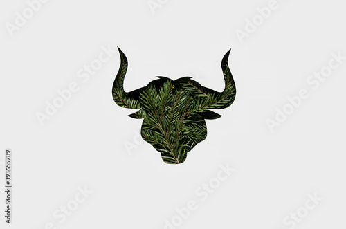 silhouette of a green bull with a Christmas trees on its body. New year 2021 card with the symbol of the year. Zero waste Christmas concept. Flat lay, top view. Flat lay, top view. paper cut bull © Julia