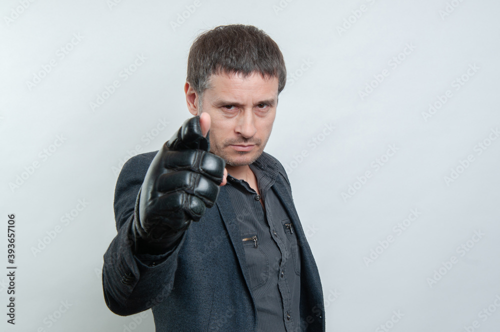 Naklejka premium Photo of a serious man with black boxing glove pointing at camera
