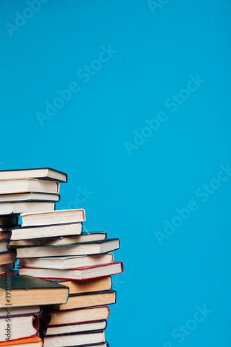 stacks of books for education in the college library on a blue background place for inscription