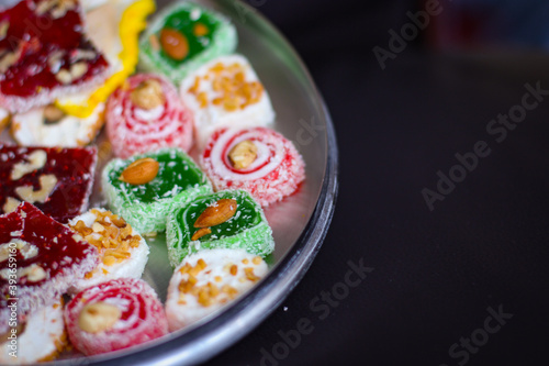 Oriental sweets in a round metal tray on a dark background