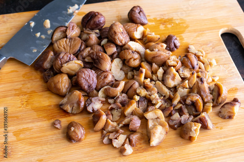 Chopped Chestnuts on a Cutting Board: Chopping roasted chestnuts on a bamboo cutting board to make chestnut dressing or stuffing
