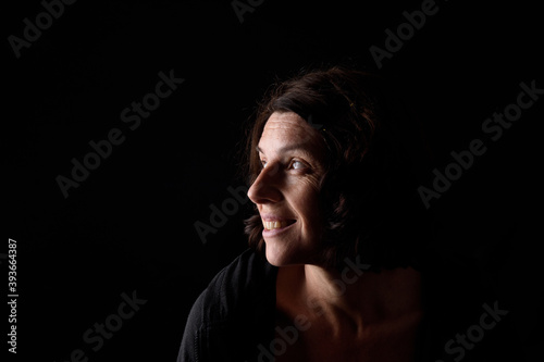 side view of a portrait of a woman on black background