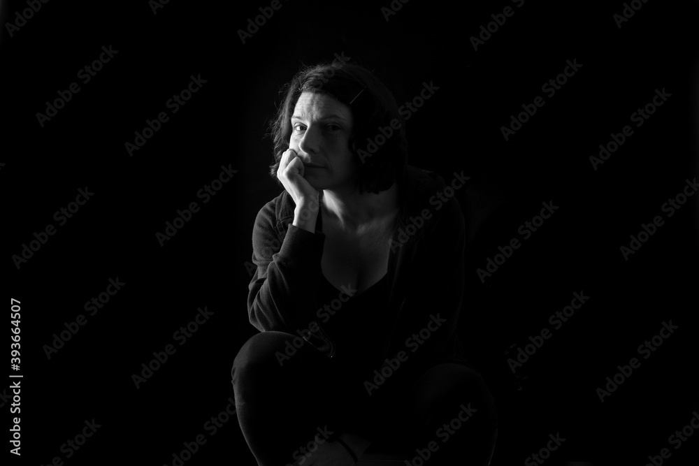 portrait of a woman sitting on black background