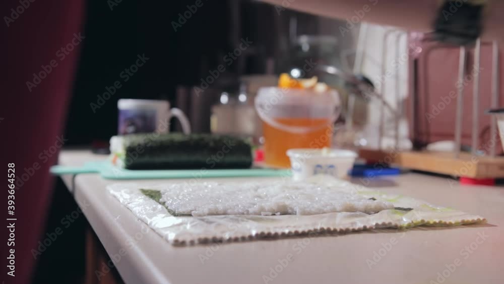 sushi cooking process. man prepares sushi. the guy is putting rice on the nori sheets. cooking food at home. time-lapse of cooking rolls sushi cooking process. man prepares sushi. the guy is putting rice on the nori sheets. cooking food at home. time-lapse of cooking rolls