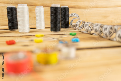 Sewing threads and other sewing accessories on a wooden table.