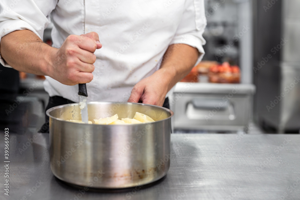 Unrecognizable Chef stirring in a pot in. High quality photo Unrecognizable Chef stirring in a pot in. High quality photo
